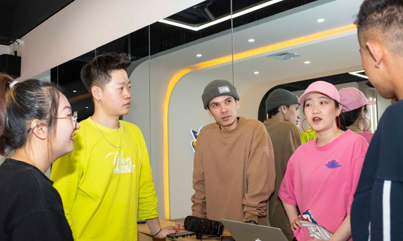 Xirli Abdukirm (3rd L) and his colleagues Dou Jiayang (1st L), Wang Xiaowu (2nd L) and Ma Jie (1st R) communicate while making tutorial videos at a street dance studio in Urumqi, northwest China's Xinjiang Uygur Autonomous Region, April 27, 2021.(Photo: Xinhua)