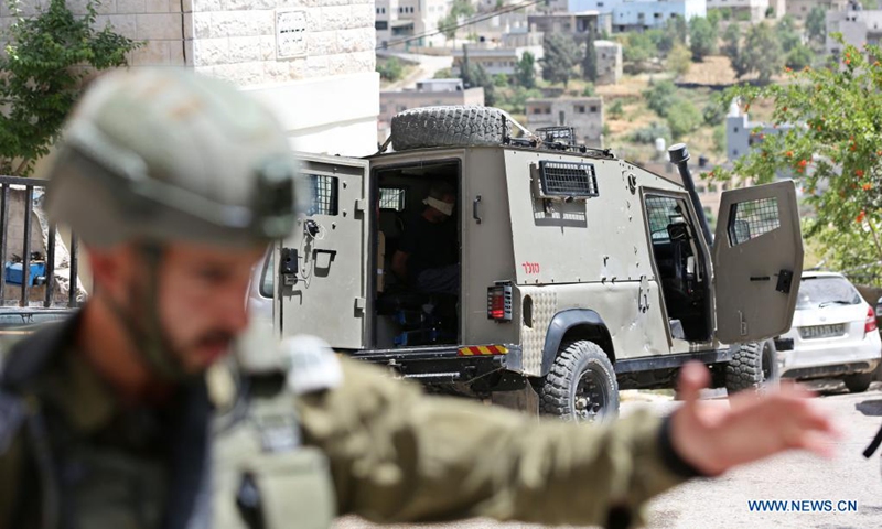 A blindfold Palestinian is seen inside an Israeli military vehicle after he was arrested during a security operation to search for Palestinians suspected in a drive-by shooting attack, in Aqraba village, east of the West Bank city of Nablus, on May 4, 2021. A drive-by shooting attack in the West Bank on Sunday afternoon injured three Israelis, including two in critical condition, Israeli authorities said. (Photo by Ayman Nobani/Xinhua)