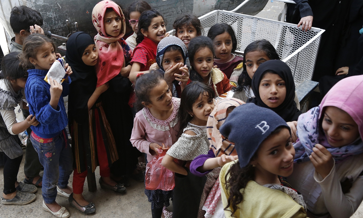 Yemeni girls from families who were affected by the war and blockade, stand in a line as they wait to receive a lunch meal from a charitable center on April 12, 2021 in Sana'a, Yemen. Photo: VCG