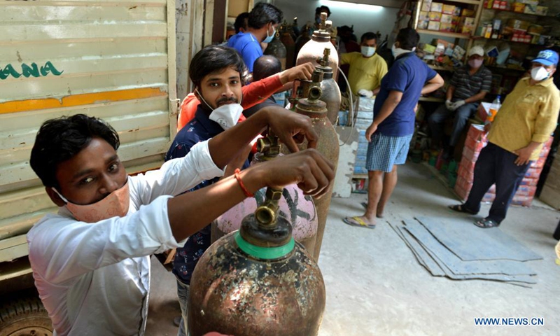 People wait to refill oxygen cylinders for COVID-19 patients at Jangpura area in New Delhi, India, on May 5, 2021.(Photo: Xinhua)