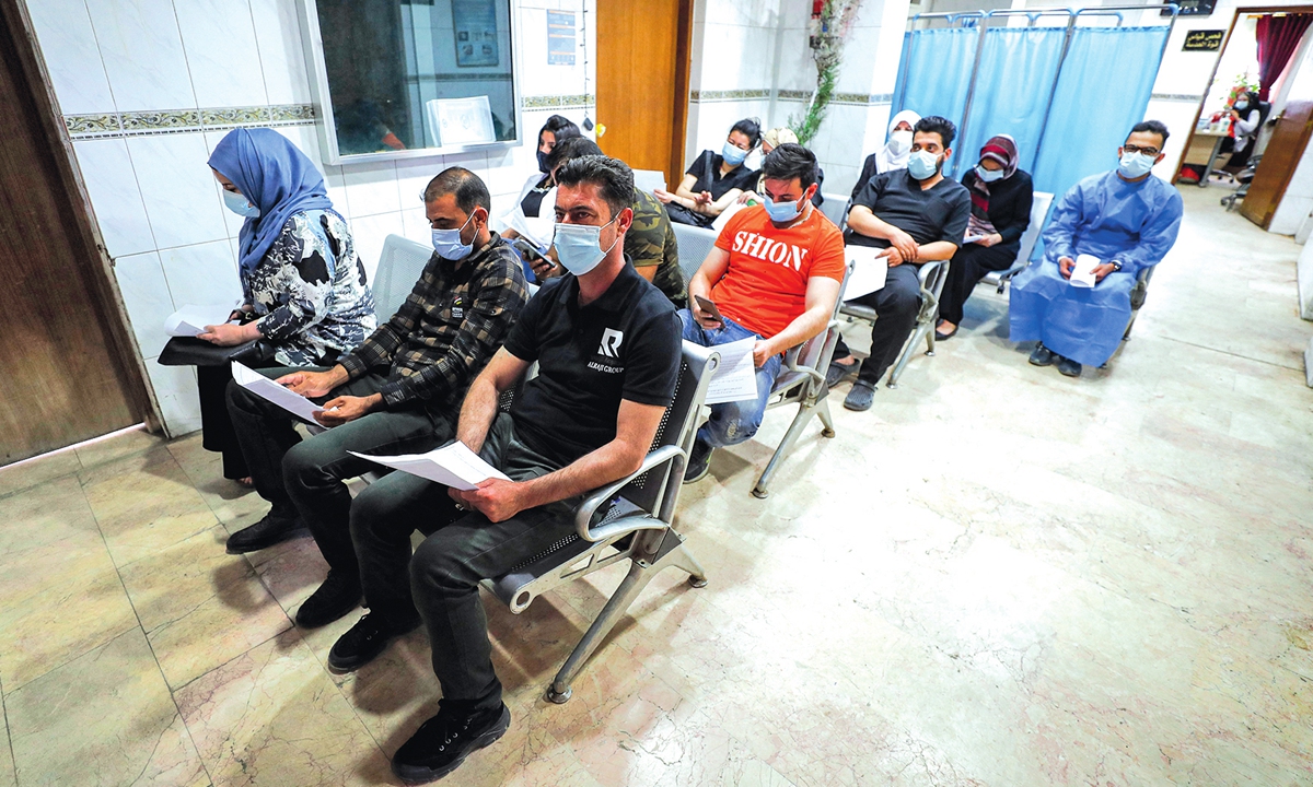 People wait to receive doses of the Pfizer-BioNTech COVID-19 coronavirus vaccine at a vaccination center in the Kindi Hospital in Iraq's capital Baghdad on April 14. Photo: AFP