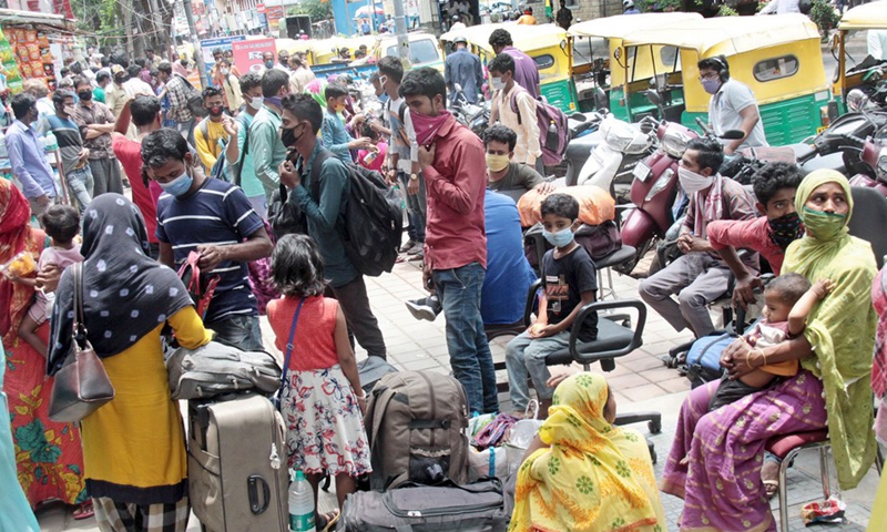 Indian migrant workers and their families are seen outside the bus transport booking center during the coronavirus pandemic, in Bangalore, India, April, 15, 2021.Photo:Xinhua
