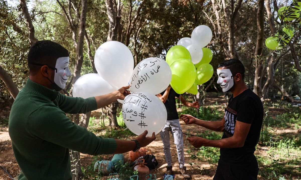 Masked Palestinian followers of the Hamas movement near Beit Lahia in the Gaza Strip, prepare to fly incendiary balloons across the northern border toward Israel, on May 8, 2021, a day after al-Quds (Jerusalem) Day. Photo: VCG