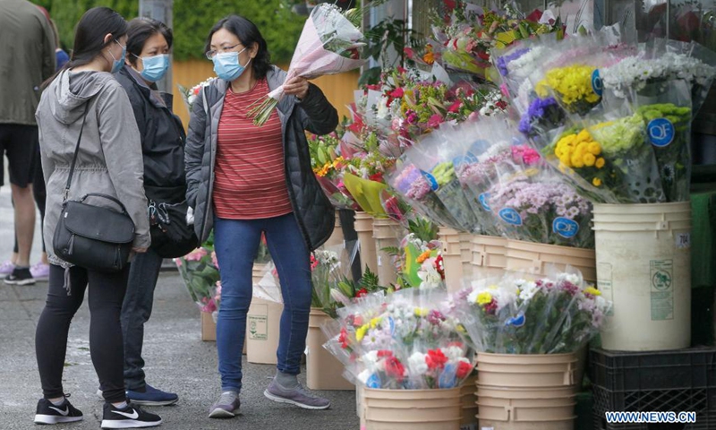 People select flowers at a flower shop ahead of Mother's Day in Burnaby, British Columbia, Canada, on May 8, 2021.(Photo: Xinhua)