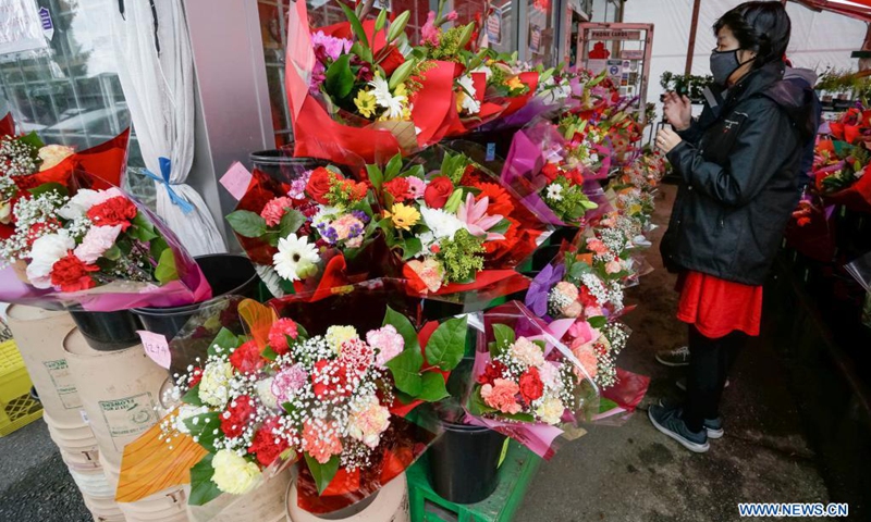 A woman selects flowers at a flower shop ahead of Mother's Day in Burnaby, British Columbia, Canada, on May 8, 2021. (Photo: Xinhua)