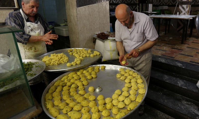 Vendors prepare traditional cookies at their shop ahead of the Eid al-Fitr festival in the West Bank city of Nablus, May 9, 2021. Eid Al-Fitr, also called the festival of breaking the fast, marks the end of the month-long fasting of Ramadan.(Photo: Xinhua)