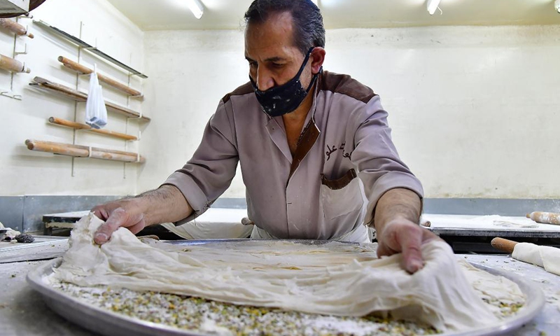 A sweet maker prepares traditional Syrian sweets for the upcoming Eid al-Fitr in Damascus, Syria, on May 9, 2021. Eid al-Fitr marks the end of the Islamic holy month of Ramadan.(Photo: Xinhua)