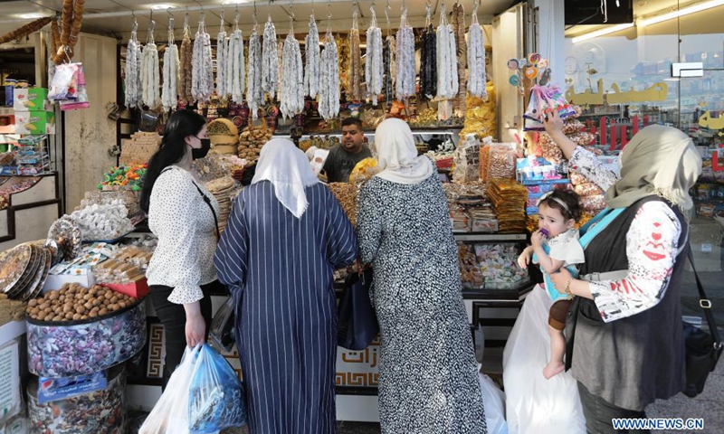People buy dried fruits and sweets for the Eid al-Fitr in Baghdad, Iraq, on May 9, 2021. Eid al-Fitr marks the end of the Islamic holy month of Ramadan.(Photo: Xinhua)