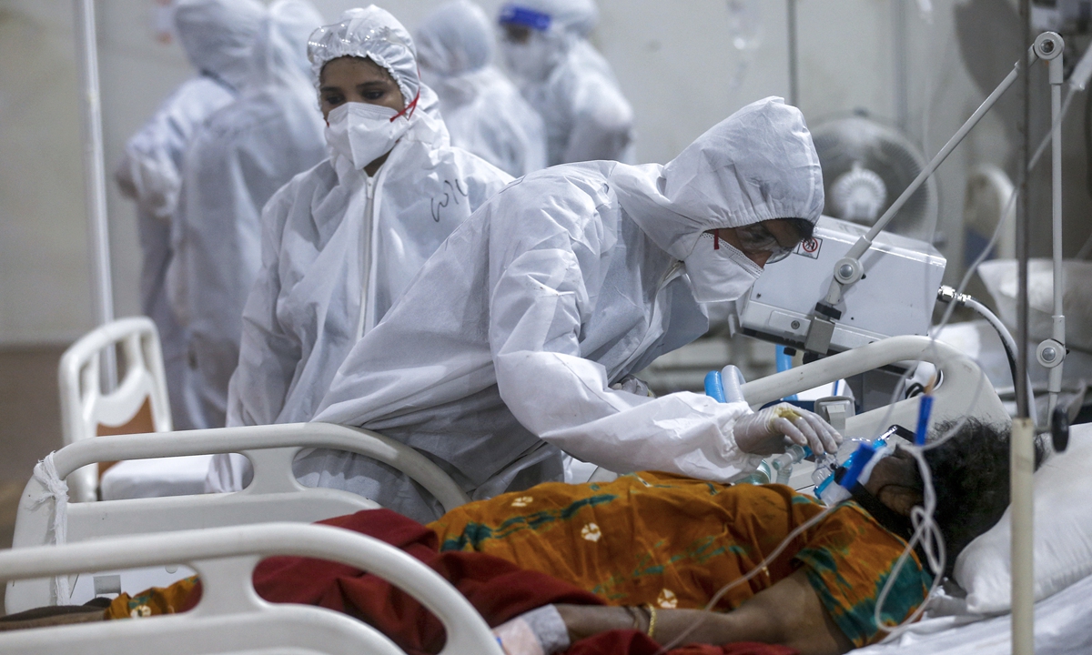A health worker tries to adjust the oxygen mask of a patient at the BKC jumbo field hospital, one of the largest COVID-19 facilities in Mumbai, India, Thursday, May 6, 2021. Photo: VCG