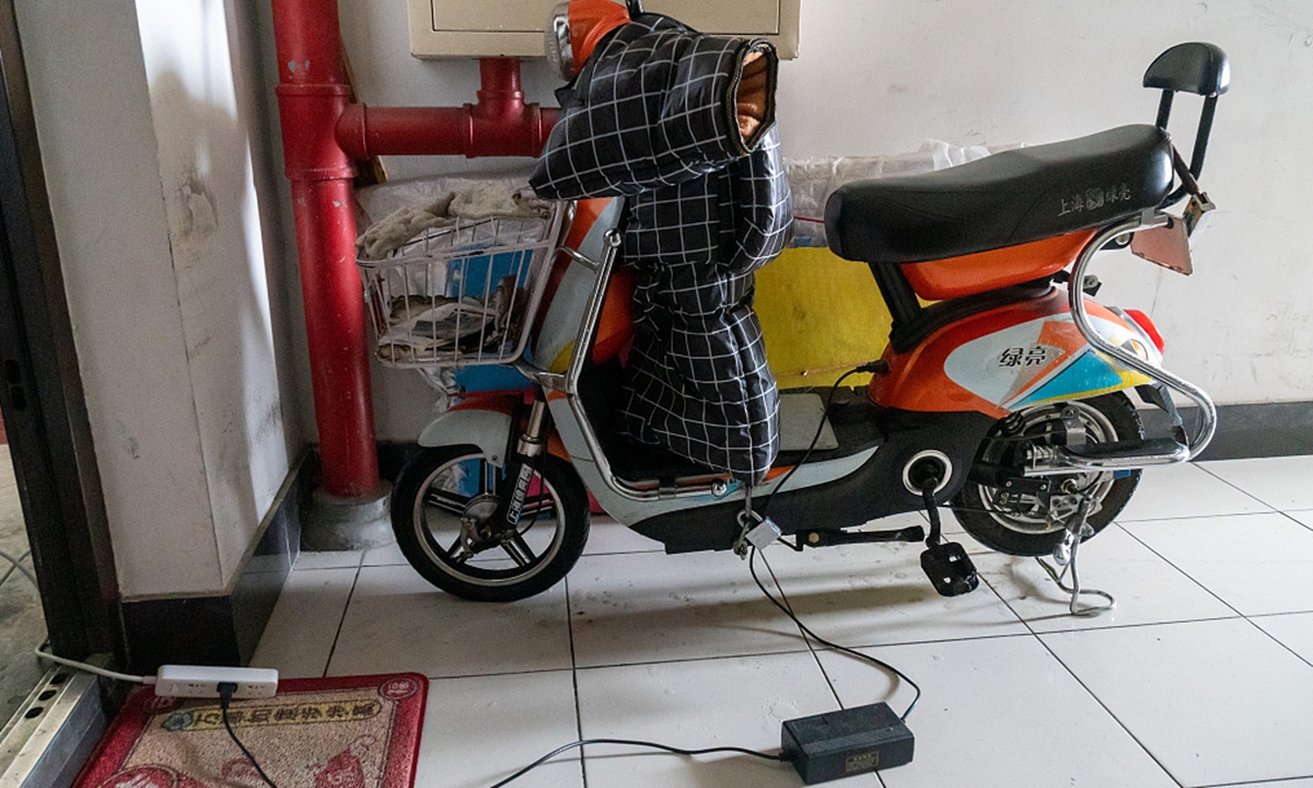 An electric bike is being charged in a residential building in Shanghai, on February 28, 2021. Photo: CFP