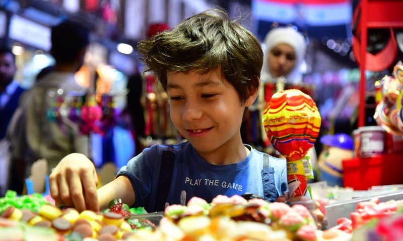 A boy chooses candies at a market in Damascus, Syria, May 11, 2021. Eid al-Fitr that marks the end of the Islamic holy month of Ramadan is approaching. Photo: Xinhua