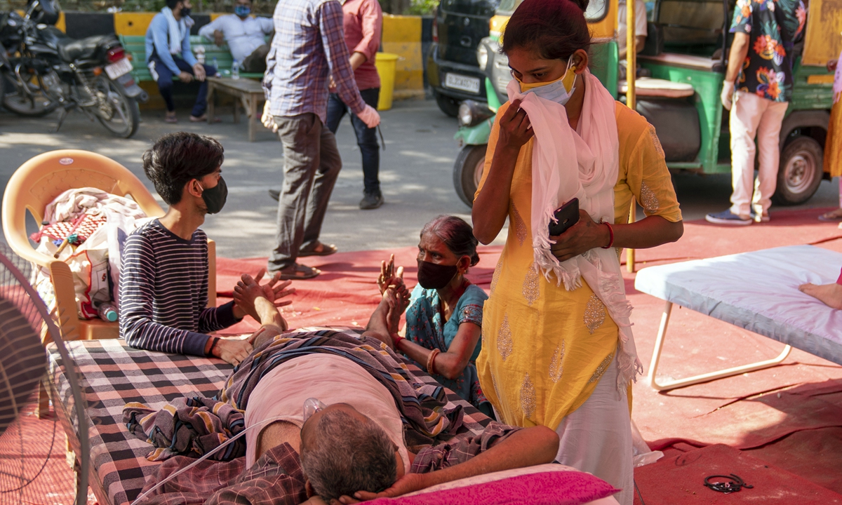 Relatives attend to a Covid-19 patient receiving free oxygen, supplied by Khalsa Help International, at the Shri Guru Singh Sabha Gurudwara in the Indirapurma township of Ghaziabad, Uttar Pradesh, India, on Tuesday, May 11, 2021. Photo: VCG