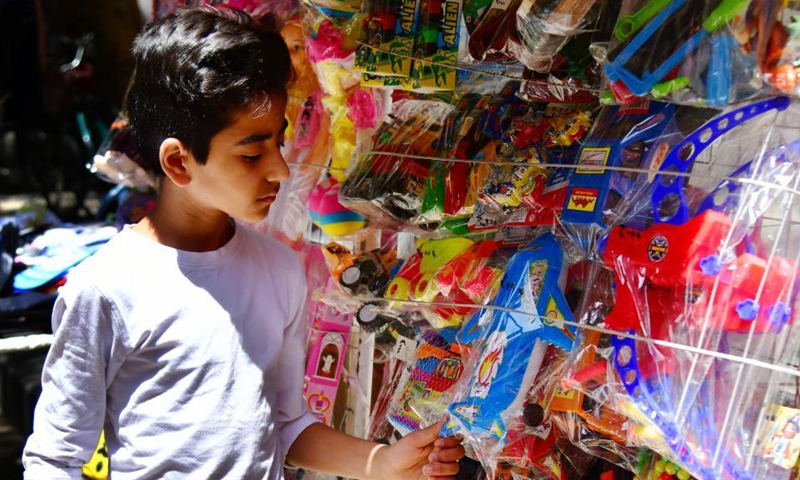 A boy chooses toys at a market in Damascus, Syria, May 11, 2021. Eid al-Fitr that marks the end of the Islamic holy month of Ramadan is approaching. Photo: Xinhua