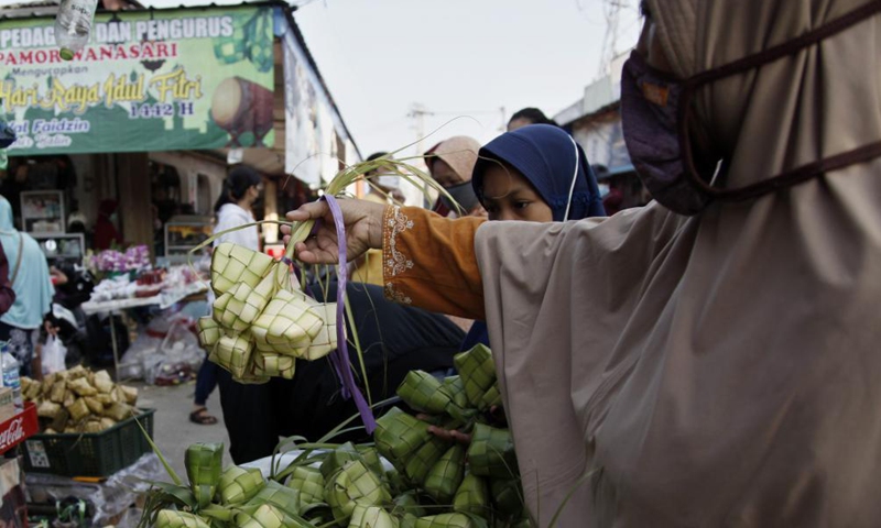 A woman buys Ketupat in Bekasi, West Java, Indonesia, on May 12, 2021. Ketupat, a traditional rice cake boiled in plaited coconut leaves, is often sold prior to Eid al-Fitr festival.   Photo: Xinhua
