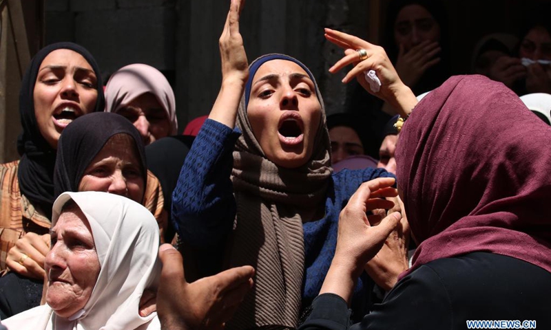 Relatives of a Palestinian teenager who was shot dead by Israeli soldiers during clashes mourn during the funeral in village of Aqqaba near the West Bank city of Tubas, on May 12, 2021.(Photo: Xinhua)