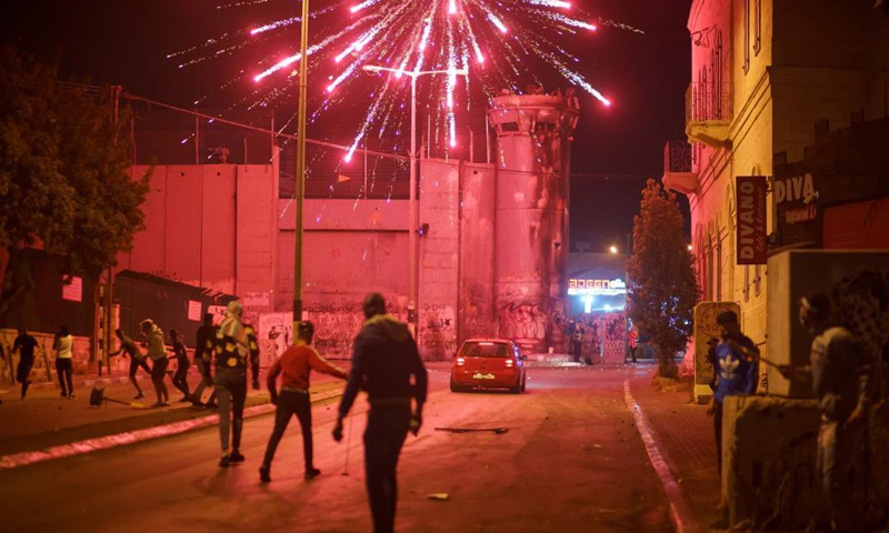 Protesters are seen during their clashes with members of Israeli border police following an anti-Israel protest against the violence in Jerusalem, in the West Bank city of Bethlehem, on May 12, 2021. Tension between Israelis and Palestinians has been flaring up over the past few days amid the escalating violence.(Photo: Xinhua)