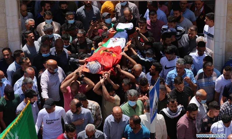 Mourners carry the body of a Palestinian teenager who was shot dead by Israeli soldiers during clashes at the funeral in village of Aqqaba near the West Bank city of Tubas, on May 12, 2021.(Photo: Xinhua)