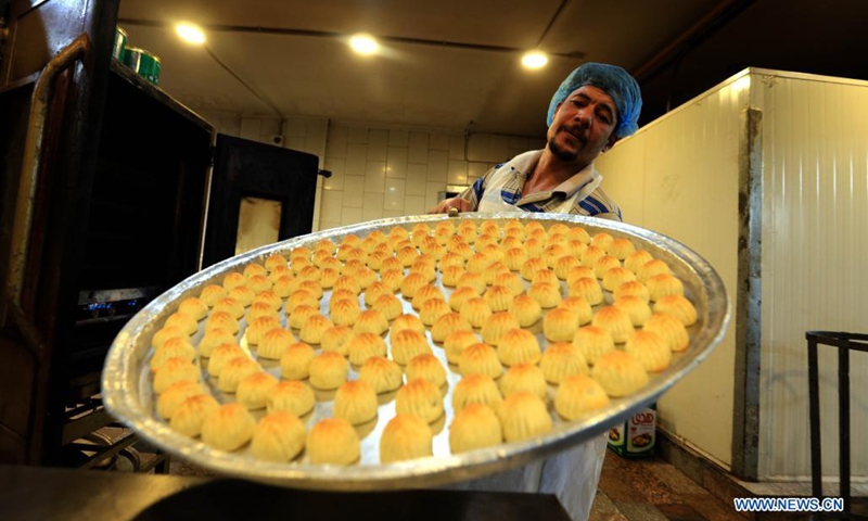 A sweet maker displays traditional sweets ahead of the Eid al-Fitr, which marks the end of the Islamic holy month of Ramadan, at a shop in Amman, Jordan, on May 12, 2021.(Photo: Xinhua)