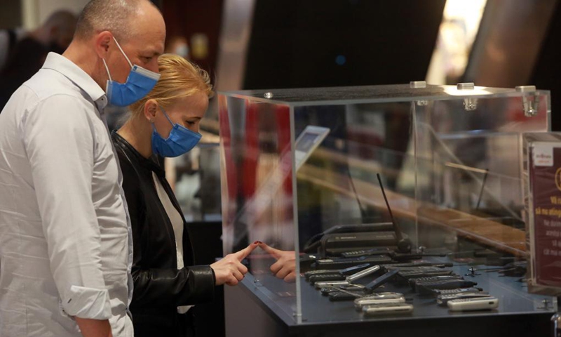 People look at obsolete mobile phones displayed at a shopping mall in Bucharest, Romania, on May 12, 2021. A 14-day telecommunication device show was held here to mark the World Telecommunication and Information Society Day, which falls on May 17 annually. The show will last utill May 23.(Photo: Xinhua)