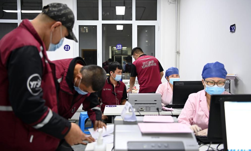 Medical workers register the information of couriers at a vaccination site in Nankai District, north China's Tianjin, May 12, 2021. A temporary vaccination site was launched to administer the second dose of COVID-19 vaccine for more than 1,000 deliverymen at Hongqi South Road of Nankai District, north China's Tianjin. The vaccination was arranged at night, in order not to affect the couriers' delivery work during the daytime.Photo:Xinhua