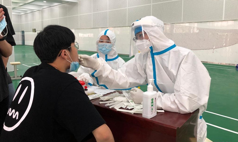 A medical worker collects a swab sample of a student for nucleic acid testing of possible COVID-19 infection at No. 1 Middle School of Lu'an City, east China's Anhui Province, May 14, 2021. Lu'an City is conducting nucleic acid tests for all residents in major urban districts of the city, starting Friday.Photo:Xinhua