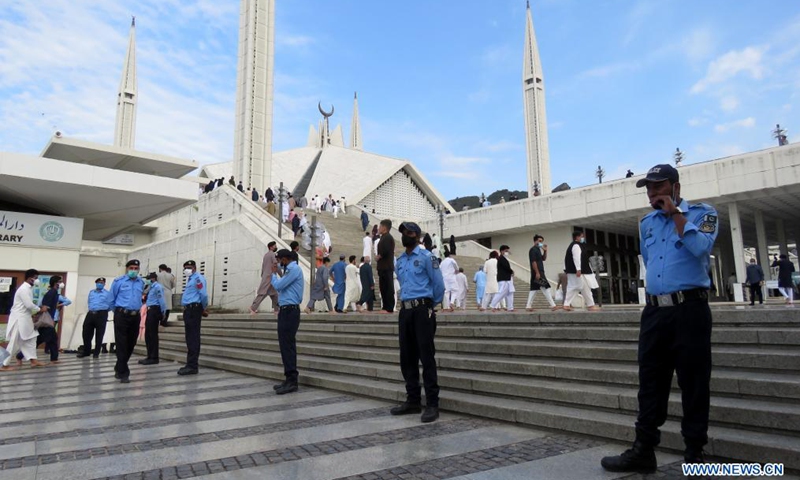 Police officers stand guard as people arrive at the Faisal Mosque to offer Eid al-Fitr prayers in Islamabad, capital of Pakistan on May 13, 2021. Eid al-Fitr marks the end of the Islamic holy month of Ramadan.Photo:Xinhua