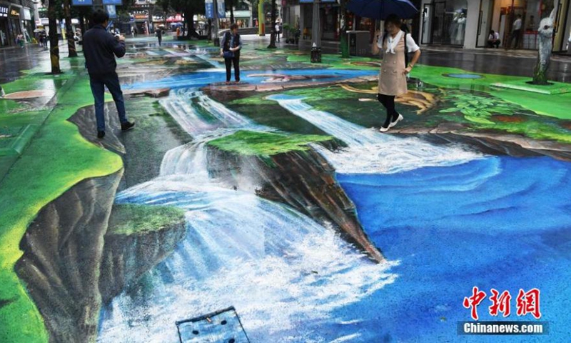 A naked eye 3D pavement painting featured with nature and ecoloy attracts tourists in Chongqing, May 12, 2021.Photo:China News Service