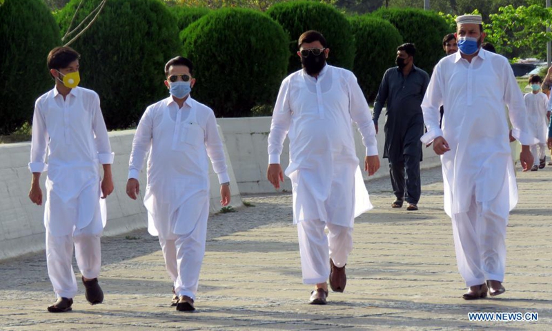 People wearing face masks arrive at the Faisal Mosque to offer Eid al-Fitr prayers in Islamabad, capital of Pakistan on May 13, 2021. Eid al-Fitr marks the end of the Islamic holy month of Ramadan.Photo:Xinhua