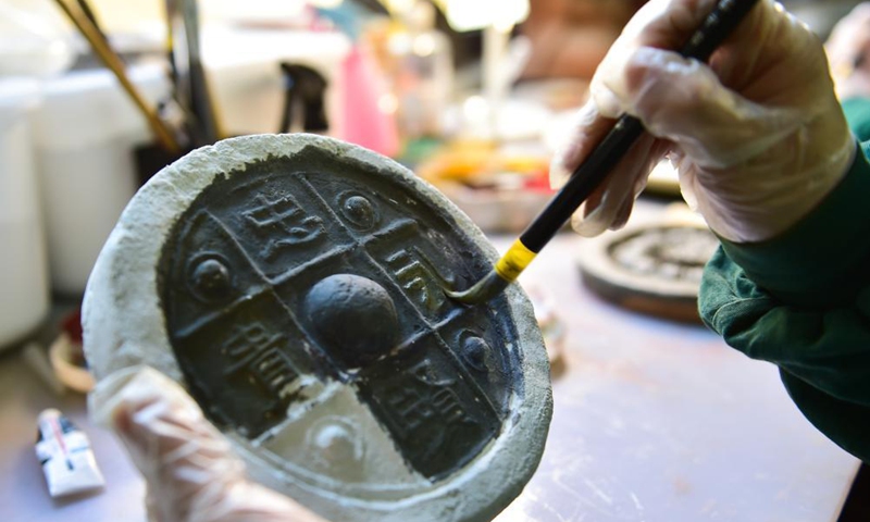 Guan Jianling, a technician with the Yungang Grottoes Research Institute, colors a piece of pottery in her studio in Datong, north China's Shanxi Province, on May 8, 2021.Photo:Xinhua