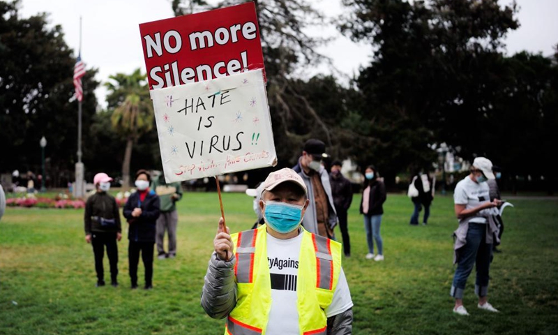 A man displays a sign at a rally against racism and hate crimes in San Mateo, California, the United States, May 15, 2021. A few hundred people including government officials and local residents from several cities in San Mateo participated in the rally on Saturday, calling for all cities and communities to unite and to stop racism and hate crimes. Photo: Xinhua