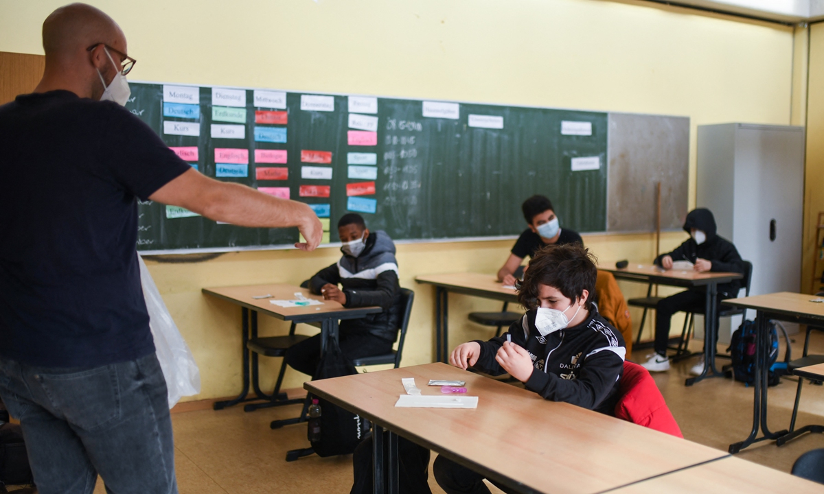 A teacher explains the use of coronavirus rapid tests to his students at the Freiherr vom Stein school in Bonn, western Germany, on Monday. Many day-care centers and schools will reopen this week with alternating classes in North-Rhine Westphalia. Photo: AFP