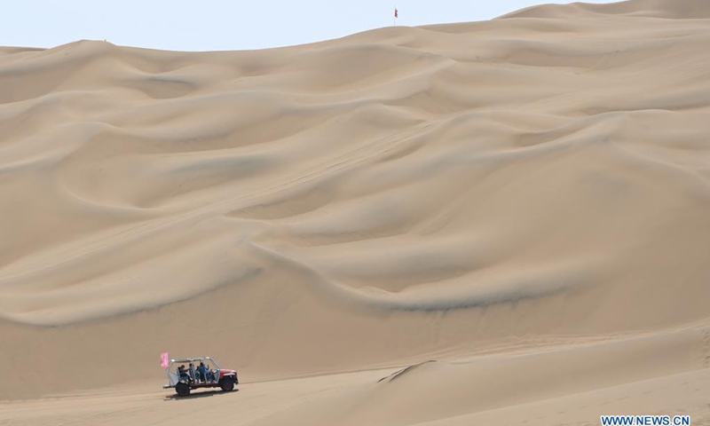 Visitors ride a sand surfing car in Kumtag Desert in Shanshan County, northwest China's Xinjiang Uygur Autonomous Region, May 16, 2021. The county sees boom in desert tourism early May.(Photo: Xinhua)