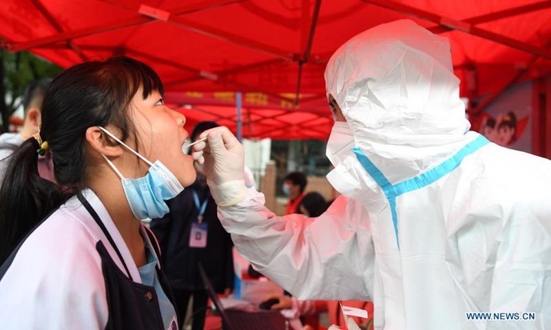 A medical worker collects a swab sample from a resident for nucleic acid testing at a community in Shangpai Township of Feixi County, east China' Anhui Province, May 16, 2021. East China's Anhui Province on Saturday reported no new confirmed, suspected or asymptomatic COVID-19 cases, the provincial health commission said Sunday. (Xinhua/Liu Junxi)