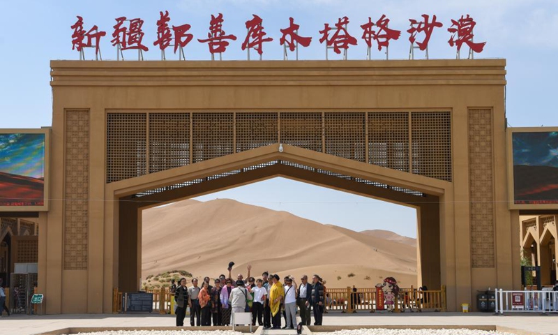 Visitors pose for photos at the entrance of Kumtag Desert in Shanshan County, northwest China's Xinjiang Uygur Autonomous Region, May 15, 2021. The county sees boom in desert tourism early May.(Photo: Xinhua)