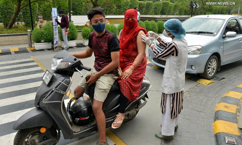 A medical worker inoculates a dose of COVID-19 vaccine to a woman at a drive-in vaccination site in Noida, India, on May 17, 2021.(Photo: Xinhua)