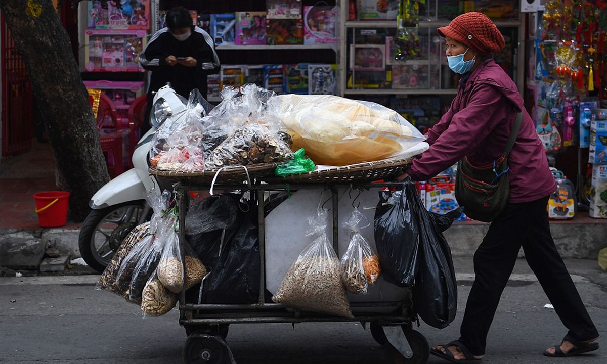 A street vendor pushes her cart full of dried goods in Hanoi, Vietnam on January 28, 2021. Photo: CFP