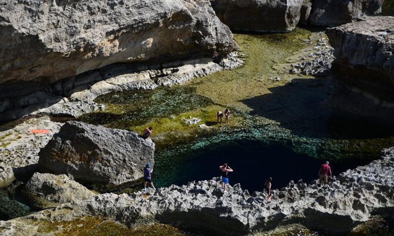 People enjoy themselves at Dwejra Bay in Gozo, Malta, May 17, 2021. The Dwejra Bay is where the natural Azure Window once stood. The natural arch collapsed in 2017.(Photo: Xinhua)