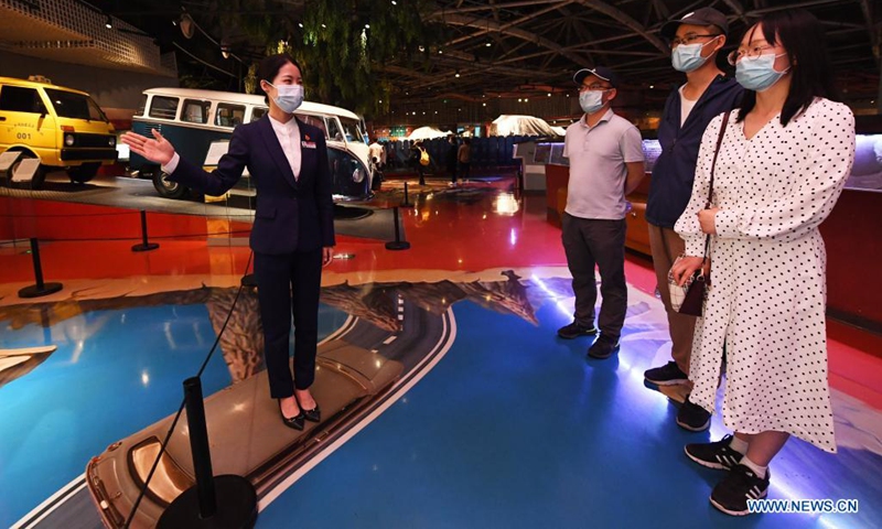 Zeng Hongjuan (1st L) introduces the car collections to visitors at Beijing Auto Museum in Beijing, capital of China, May 16, 2021. Zeng Hongjuan, who was born in the 1990s, is a tour guide at the Beijing Auto Museum. Since taking this job, Zeng has been always thinking about how to introduce automobile knowledge and development history to the audience in plain language.(Photo: Xinhua)