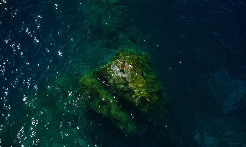 A man swims at Dwejra Bay in Gozo, Malta, May 17, 2021. The Dwejra Bay is where the natural Azure Window once stood. The natural arch collapsed in 2017. (Photo: Xinhua)