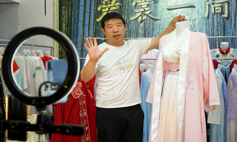 A merchant showcases Hanfu in Caoxian, East China's Shandong Province. Photo: Qi Xijia/GT
