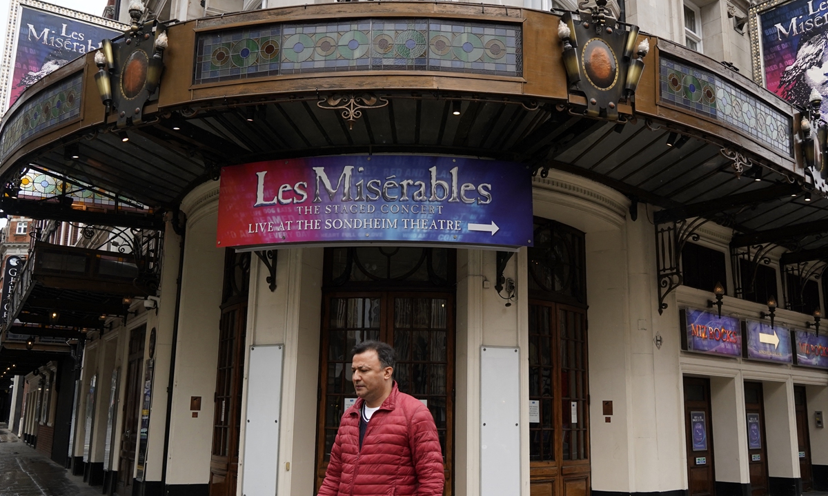 A pedestrian passes the Sondheim Theatre in central London on Sunday. Photo: AFP
