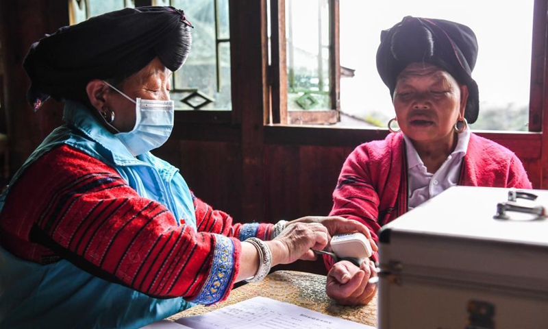 Pan Jiping checks a villager's blood pressure at Xiaozhai Village of Longji Township, Longsheng County, south China's Guangxi Zhuang Autonomous Region, May 18, 2021.(Photo: Xinhua)