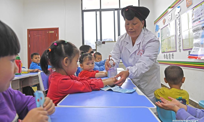 Pan Jiping teach children to use hand sanitizer at Xiaozhai Village of Longji Township, Longsheng County, south China's Guangxi Zhuang Autonomous Region, May 18, 2021.(Photo: Xinhua)