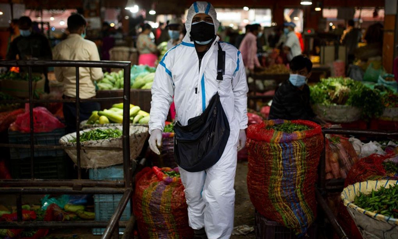 A man wearing protective suit is seen at a local market in Kathmandu, Nepal, May 18, 2021.(Photo: Xinhua)