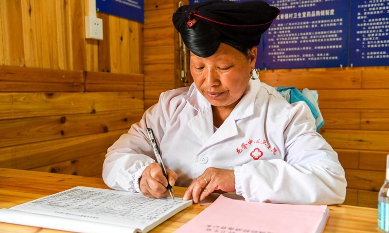 Pan Jiping fills in a working journal at Xiaozhai Village of Longji Township, Longsheng County, south China's Guangxi Zhuang Autonomous Region, May 18, 2021. In Xiaozhai, a village at the foot of Fupingbao Mountain over 1,900 meters above sea level, Pan Jiping has been a country doctor here for more than 30 years.(Photo: Xinhua)