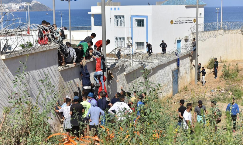 Immigrants climb over the border fence to enter the Spanish enclave of Ceuta, in Fnideq, Morocco, May 18, 2021. The Spanish enclave of Ceuta is having to deal with an influx of immigrants after an estimated 6,000 people have entered the territory from Morocco, according to the central government's delegation in the city. Photo:Xinhua