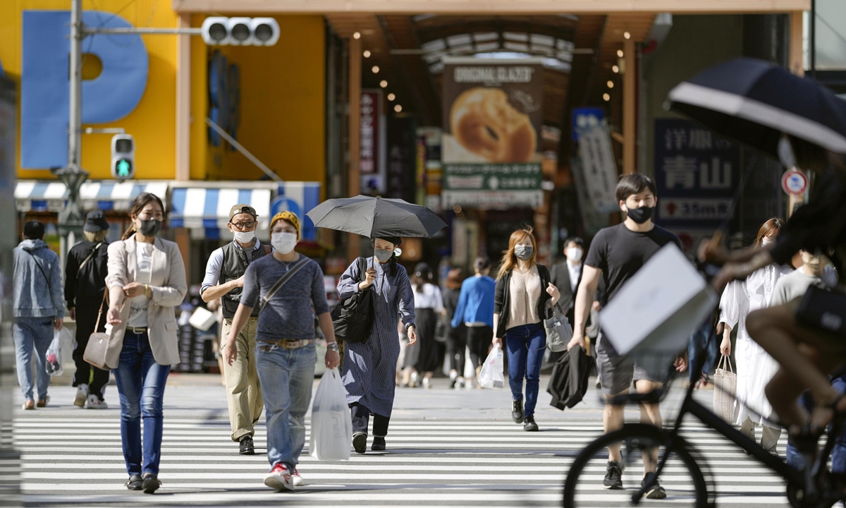 People wearing face masks walk in Osaka's Shinsaibashi area on May 13, 2021. Photo: VCG
