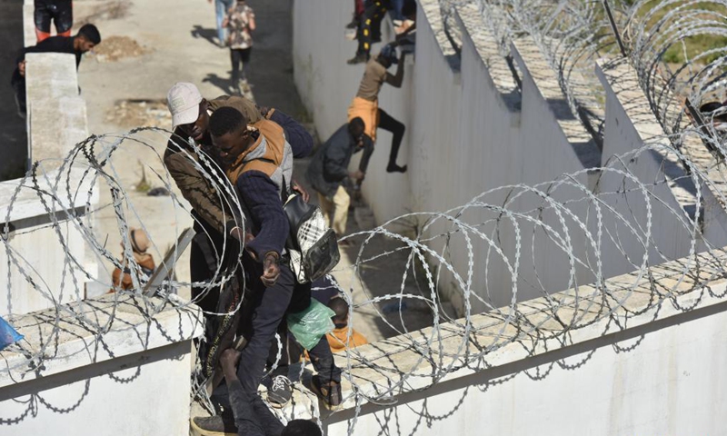 Immigrants climb over the border fence to enter the Spanish enclave of Ceuta, in Fnideq, Morocco, May 18, 2021. The Spanish enclave of Ceuta is having to deal with an influx of immigrants after an estimated 6,000 people have entered the territory from Morocco, according to the central government's delegation in the city. Photo:Xinhua