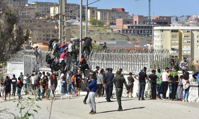 Immigrants climb over the border fence to enter the Spanish enclave of Ceuta, in Fnideq, Morocco, May 18, 2021. The Spanish enclave of Ceuta is having to deal with an influx of immigrants after an estimated 6,000 people have entered the territory from Morocco, according to the central government's delegation in the city. Photo:Xinhua