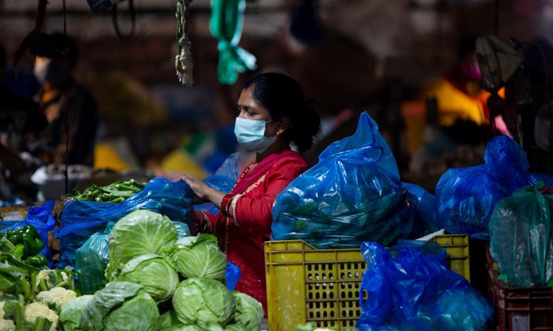 A vendor wearing a face mask is seen at a local market in Kathmandu, Nepal, May 19, 2021.(Photo: Xinhua)